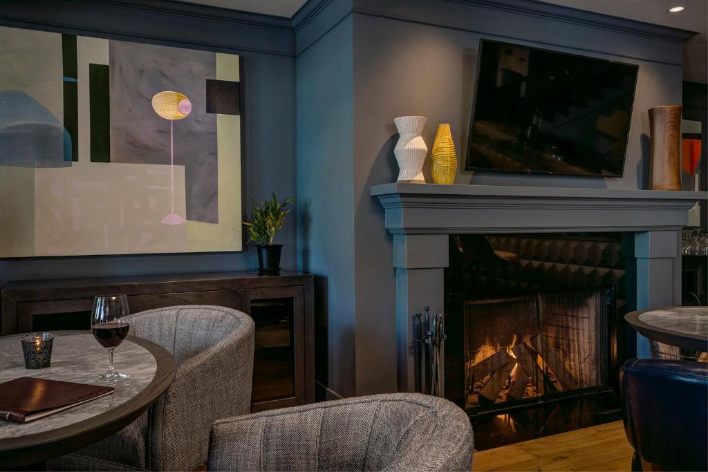 a dining room with a fireplace and a table and chairs at Hotel Arts Kensington in Calgary