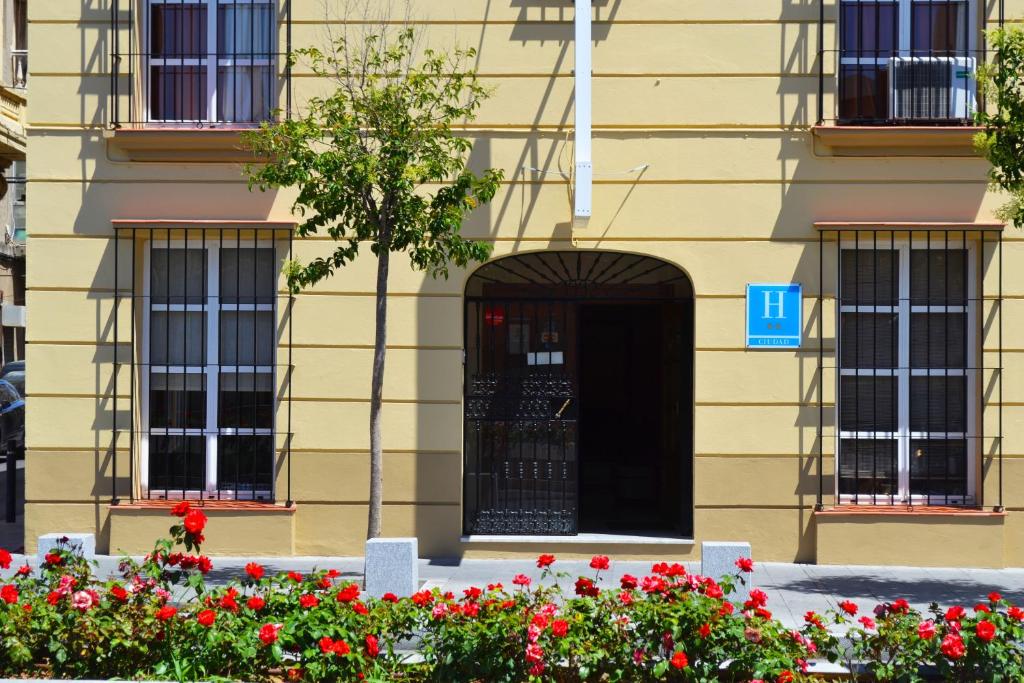 un edificio con una puerta negra y flores rojas en Hotel Don Manuel en Algeciras