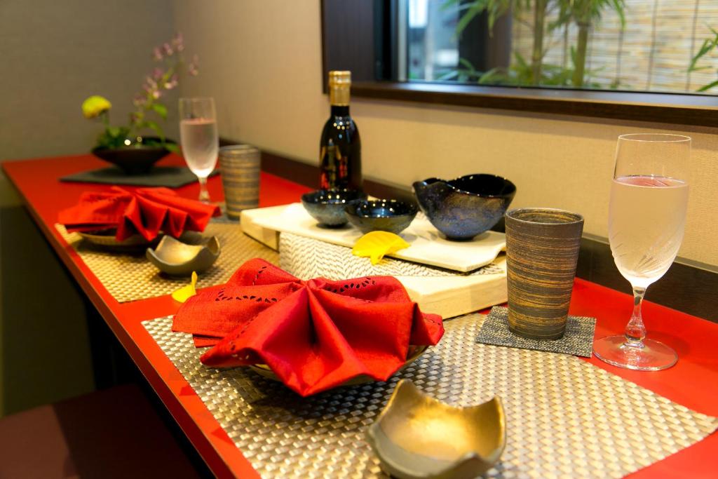 einen Tisch mit einem roten Tischtuch und Weingläsern in der Unterkunft Hosta Umekoji Miyabi in Kyoto