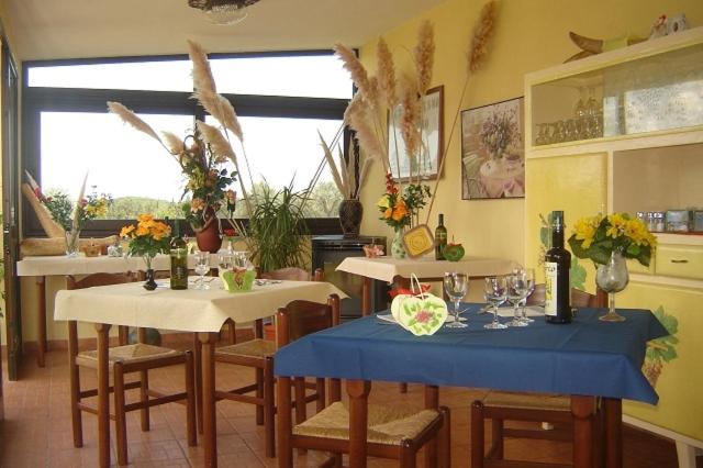 een eetkamer met 2 tafels en stoelen met bloemen erop bij Agriturismo Isidoro in Fertilia