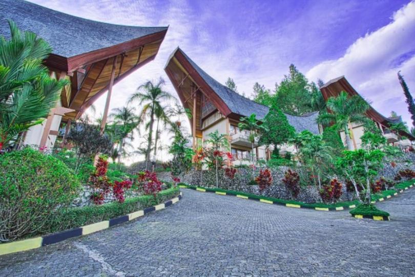 a building with a lot of flowers in front of it at Hotel Sahid Toraja in Makale