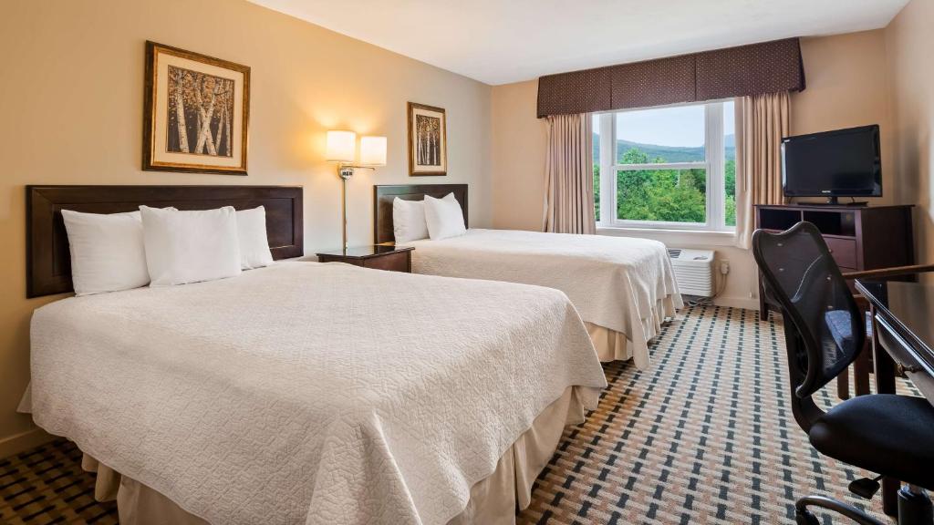 a hotel room with two beds and a window at Silver Fox Inn in Waterville Valley