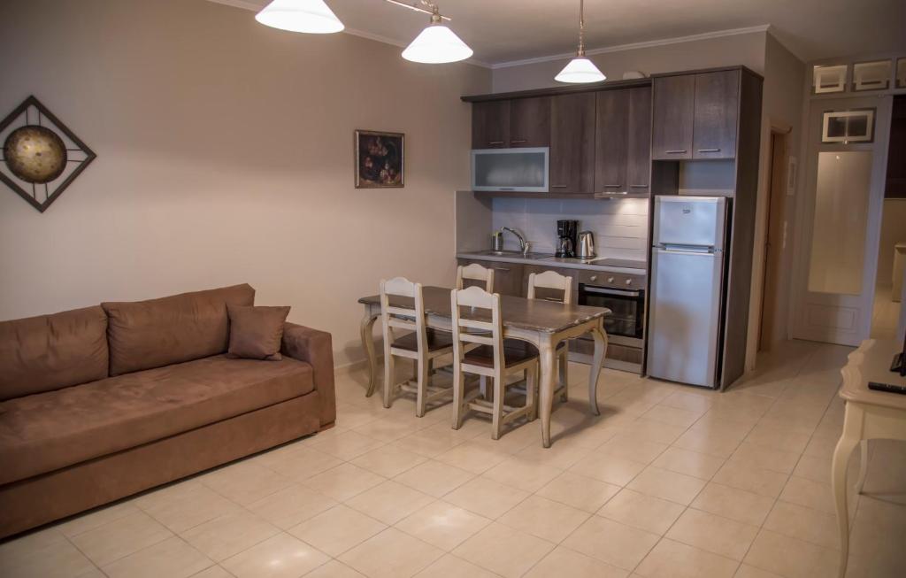 ルツァにあるAperanto House Paralia Loutsasのリビングルーム(ソファ、テーブル付)、キッチンが備わります。