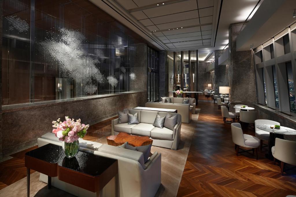 a lobby of a hotel with couches and tables at Signiel Seoul in Seoul
