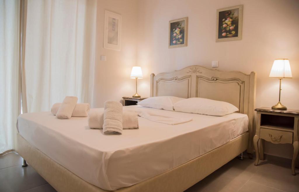 1 dormitorio con 1 cama blanca grande y toallas. en Casa Christabella, en Paralia Vrachou