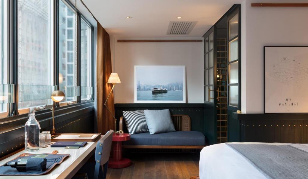a hotel room with a bed and a desk and window at The Fleming Hong Kong in Hong Kong
