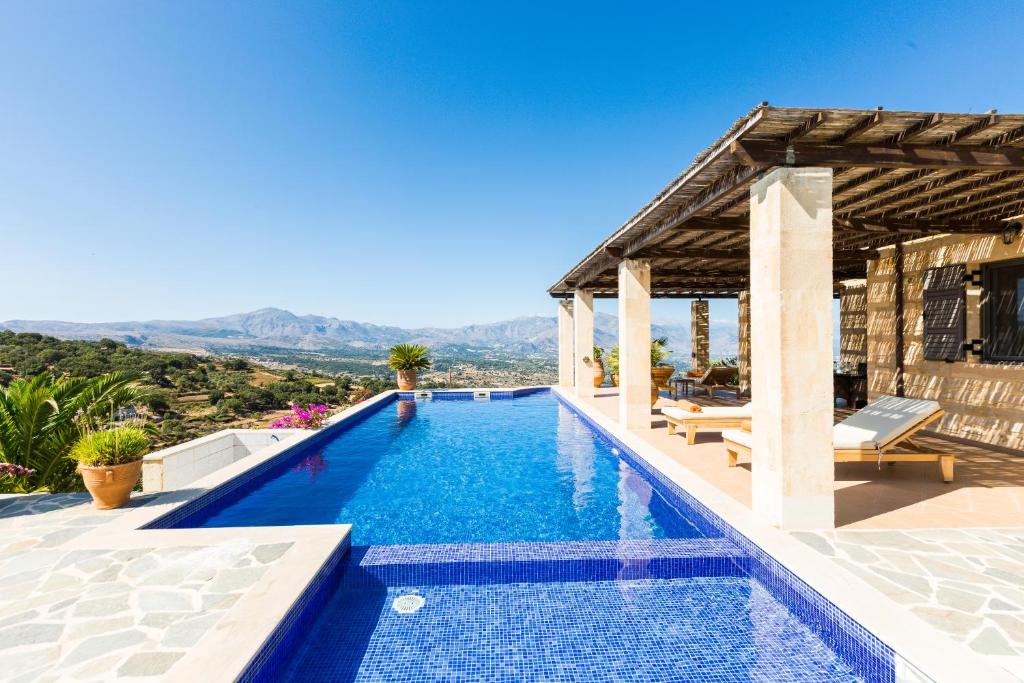 a swimming pool in a villa with a view at Jacopo Villa, untamed beauty, By ThinkVilla in Kástellos