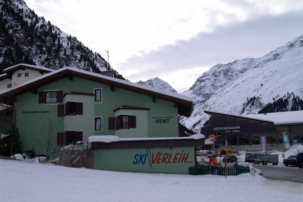 un bâtiment dans la neige à côté d&#39;une montagne dans l&#39;établissement Haus Pechtl, à Sankt Leonhard im Pitztal