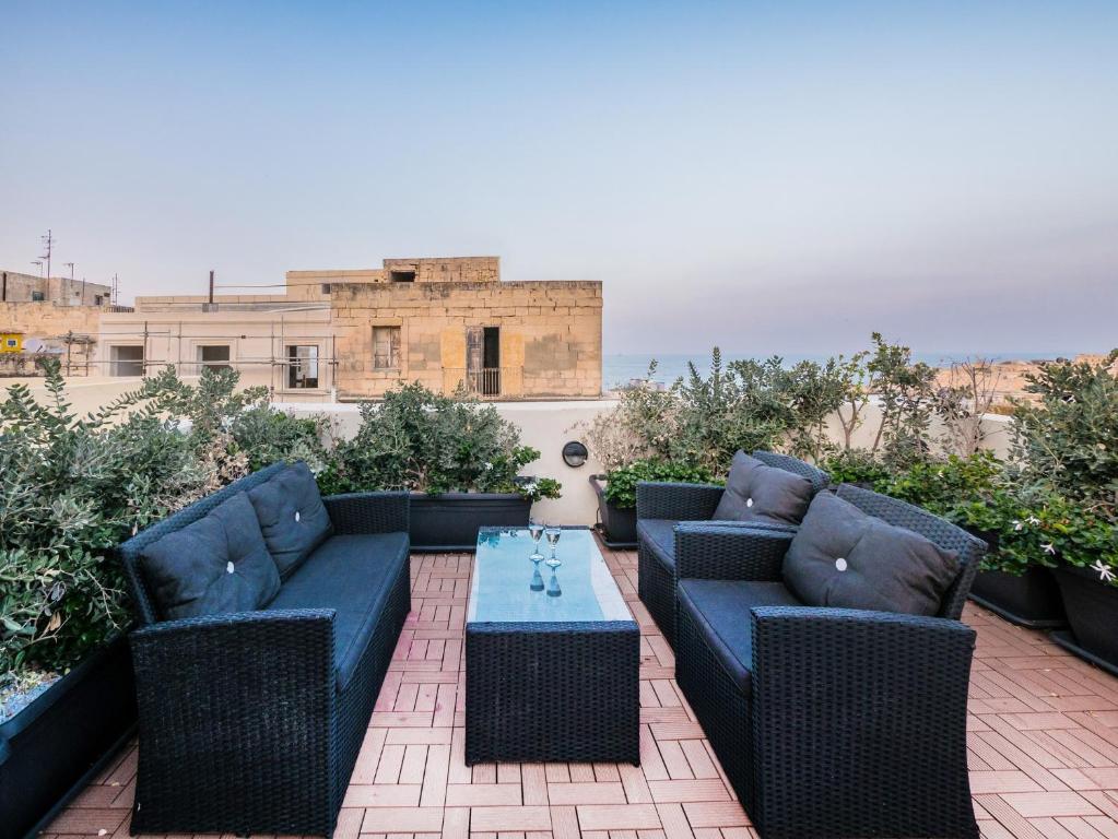 un patio con 2 sofás azules y una mesa en Valletta Kursara Port View, en La Valeta