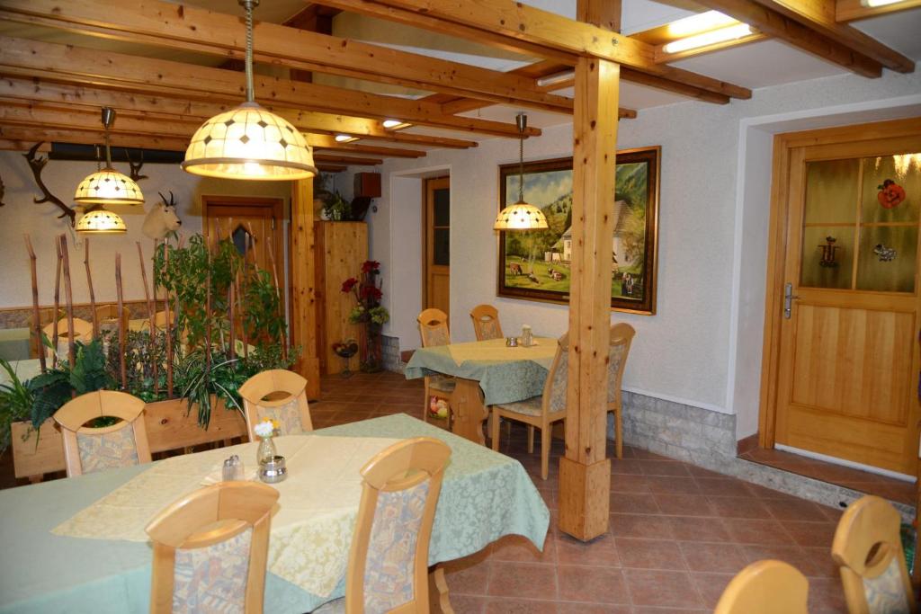 un restaurante con 2 mesas, sillas y luces en Apartmaji Rabič en Bohinj