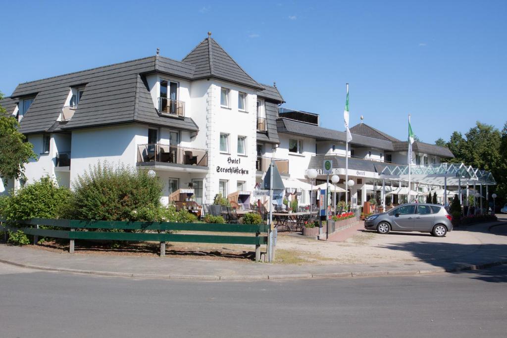 ein weißes Gebäude mit einem davor geparkt in der Unterkunft Seeblick in Mühbrook