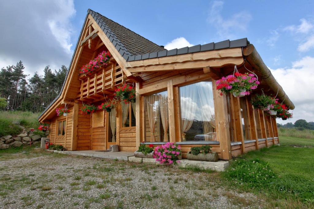 a small log cabin with flowers on it at Les Chalets du Mazet Saint Voy in Mazet-Saint-Voy