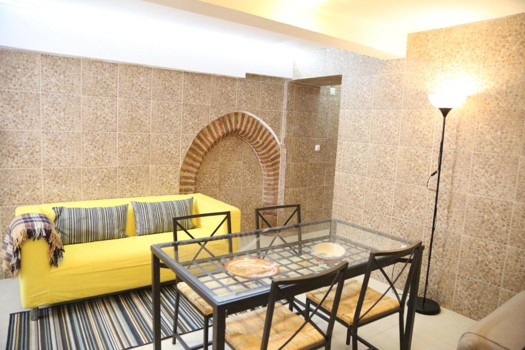 a living room with a yellow couch and a glass table at Casa da Avó in Elvas