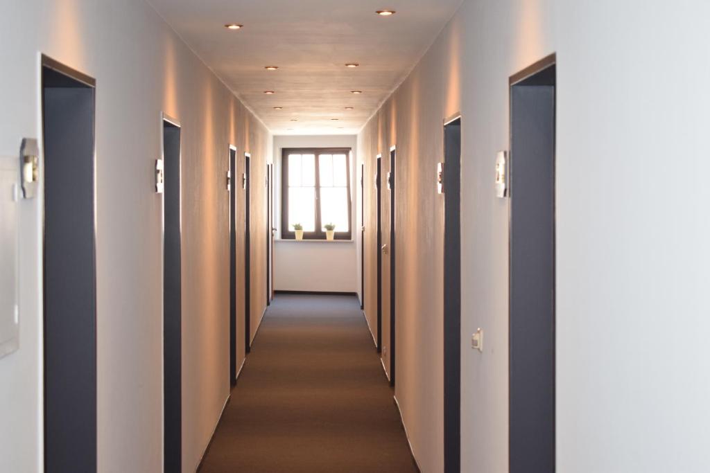 un pasillo de un pasillo del hospital con una fila de puertas en Schützenhof, en Neuhof