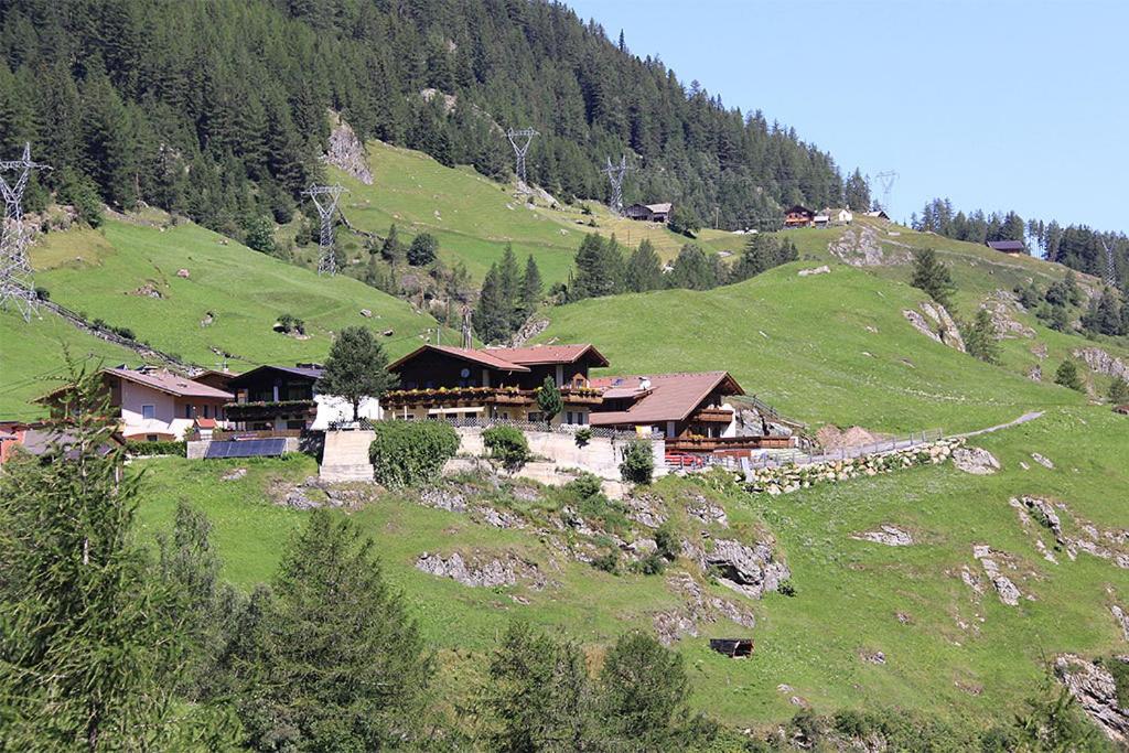 a house on top of a green hill at Gasthof Pension Granstein in Sölden