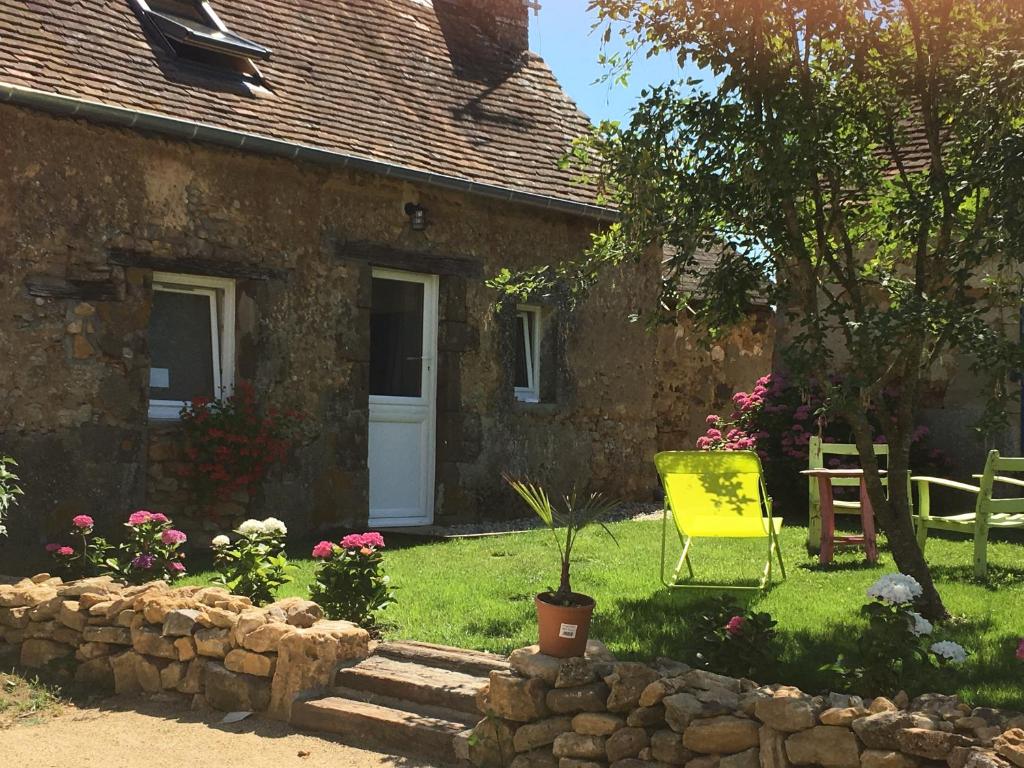 a yellow chair in the yard of a house at La Marchanderie in Spay