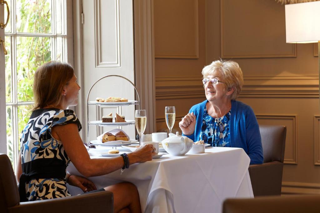 a woman sitting at a table talking to another woman at The Royal Hotel in Ventnor