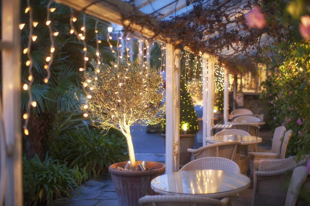 a restaurant with tables and a tree with lights at The Royal Hotel in Ventnor
