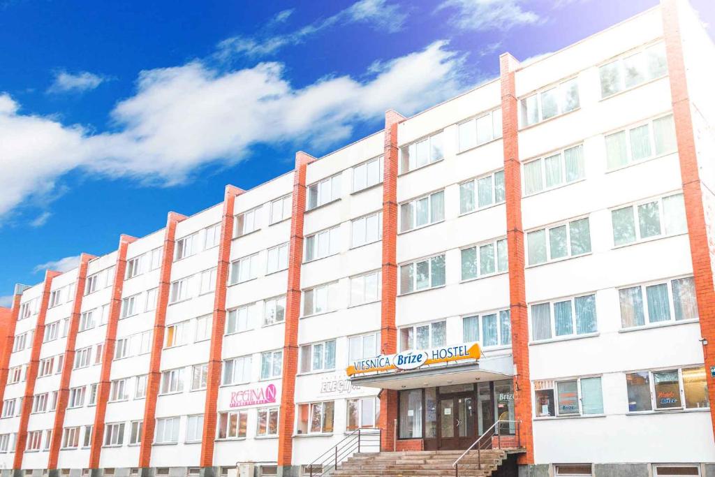 a large white building with a sign on it at Hostel Brize in Liepāja