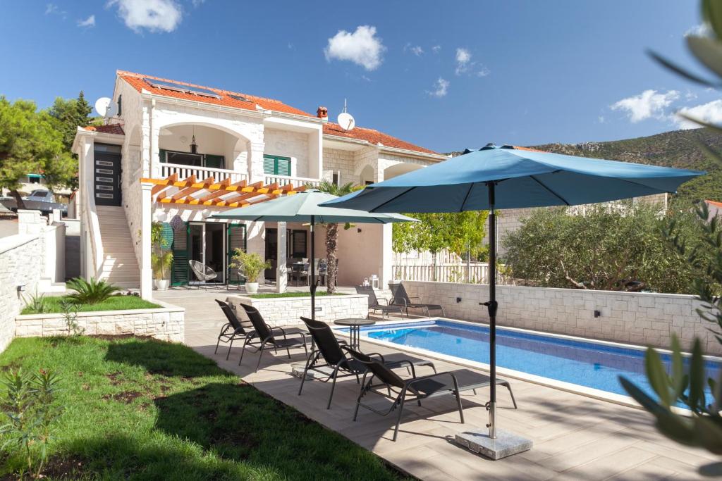 a patio with two umbrellas and a swimming pool at BOLero in Bol