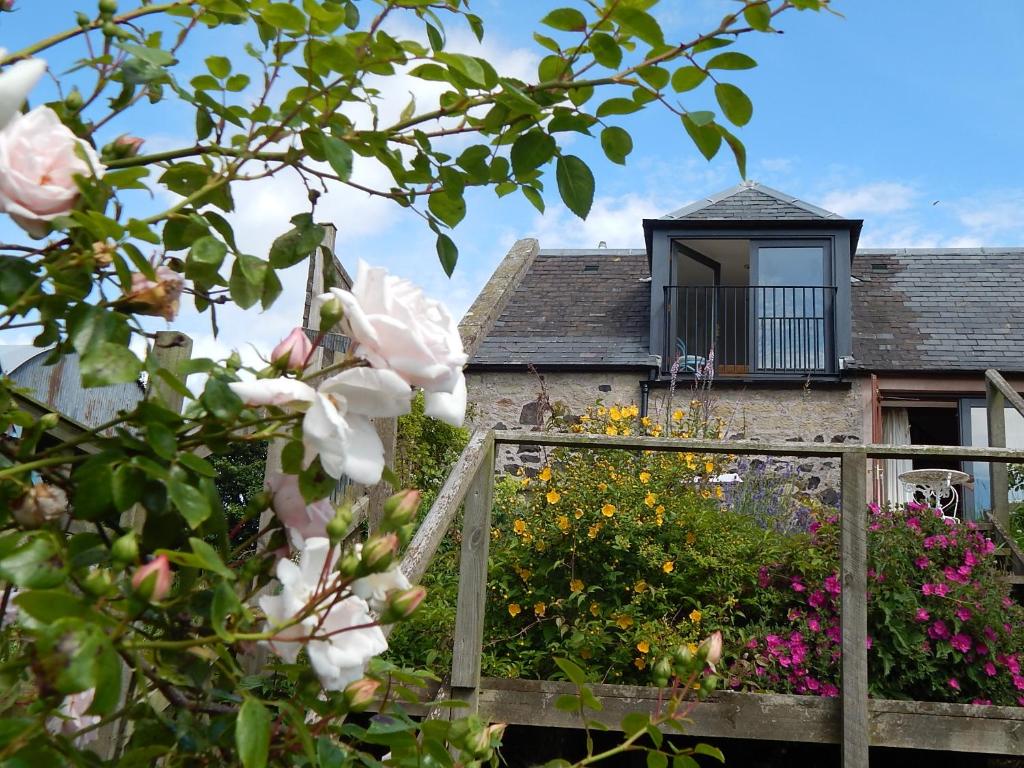 凱爾索的住宿－Plumtree Cottage，一座花园,在房子前种有鲜花