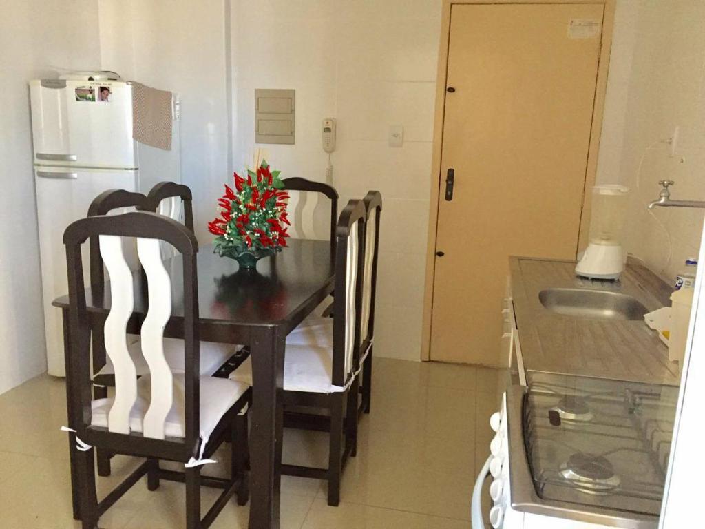 cocina con mesa, 2 sillas y nevera en Lindo e espacoso apartamento - Aracaju, en Aracaju