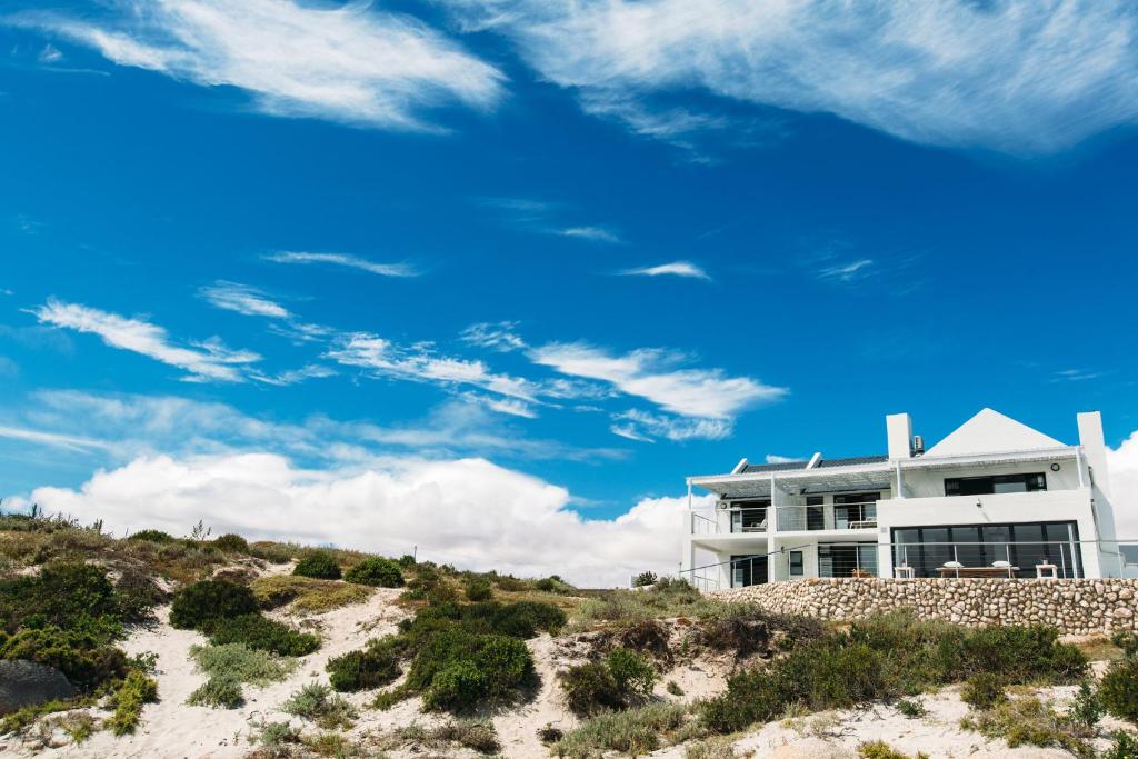 a white building on top of a sandy beach at Linhof Boutique Guest House in Paternoster