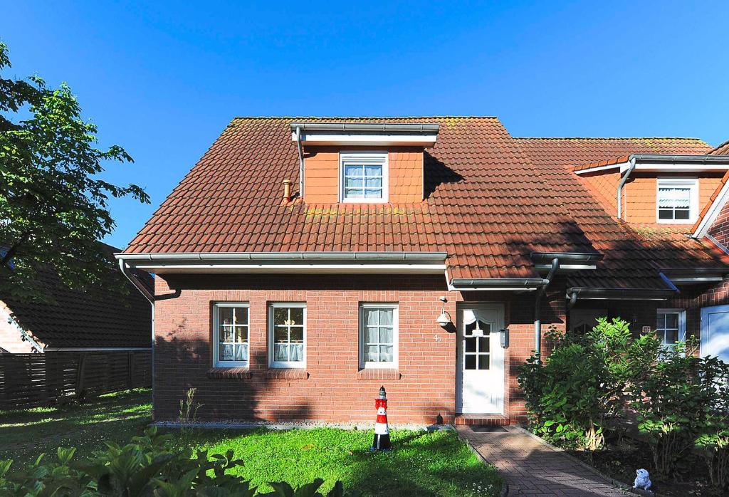 エセンスにあるFerienhaus Strandkorbの赤い屋根の茶色レンガ造り