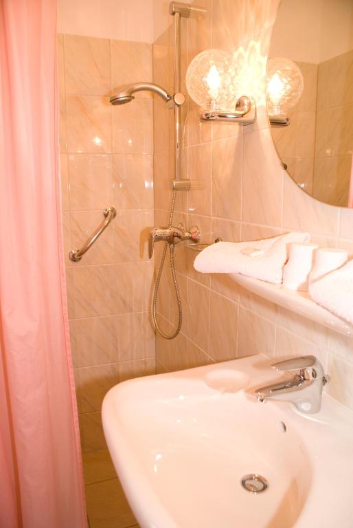 een badkamer met douche, wastafel en toilet bij Hotel Excelsior in Den Haag
