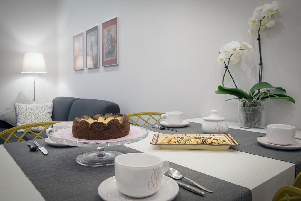 - une table à manger avec un gâteau et des tasses à café dans l'établissement L'Appartamento del Corso, à Santarcangelo di Romagna