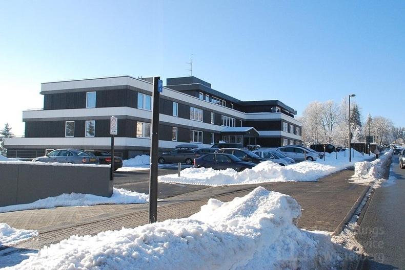 a parking lot covered in snow in front of a building at Studio am Waltenberg in Winterberg