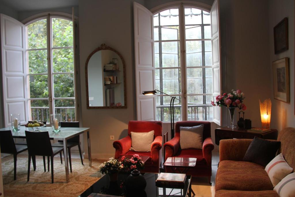セビリアにあるLuxurious 2 bedroom flat in a historic buildingのリビングルーム(ソファ、椅子、テーブル付)