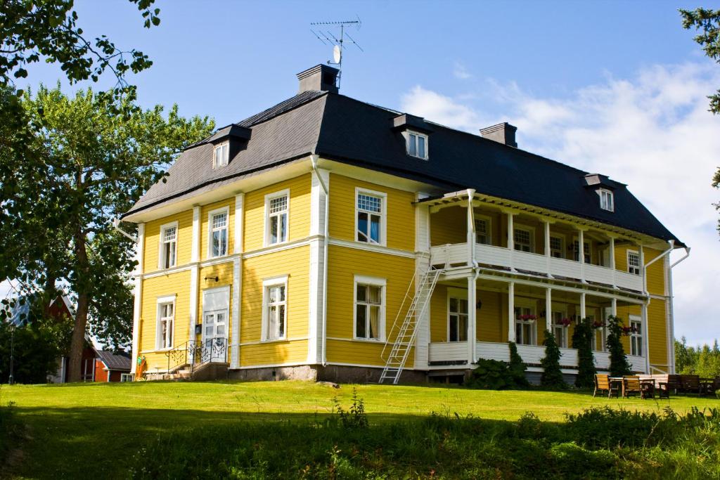 una gran casa amarilla con techo negro en Melderstein Herrgård en Råneå