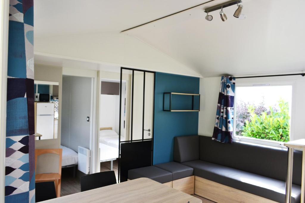 a living room with a couch and a window at Village Océanique in Le Bois-Plage-en-Ré