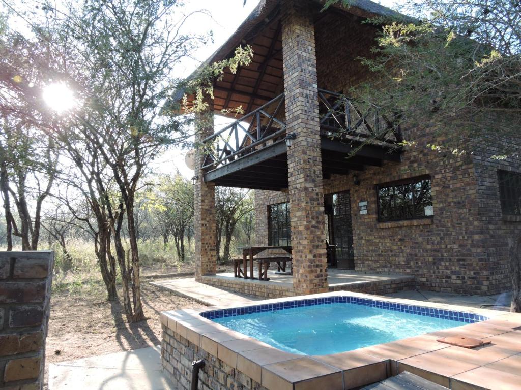 an outdoor swimming pool in front of a house at Umvangazi Rest in Marloth Park