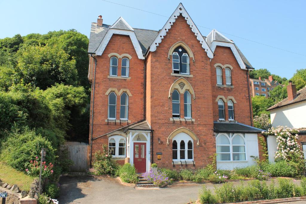 a large brick house with a red door at Ashbury Bed & Breakfast in Great Malvern