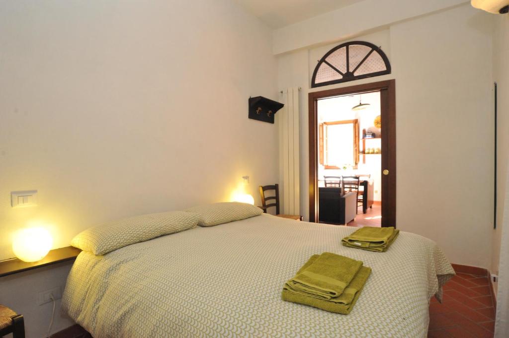 a bedroom with a bed with two green towels on it at Romantico 36 in Città della Pieve