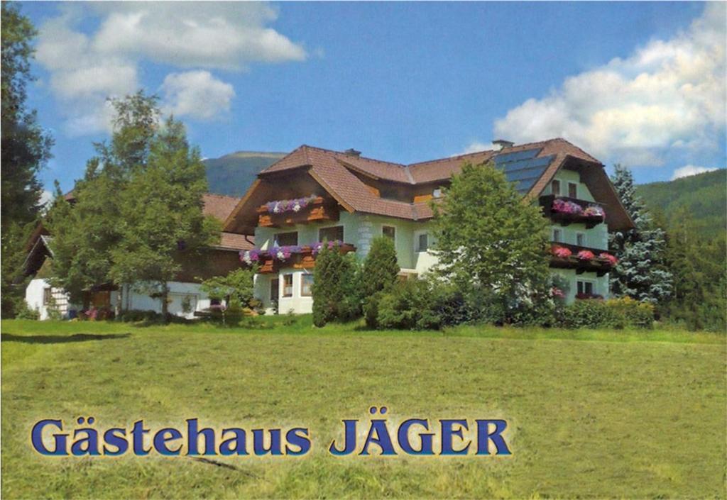 een groot huis in een veld voor een tuin bij Gästehaus Jäger in Mariapfarr