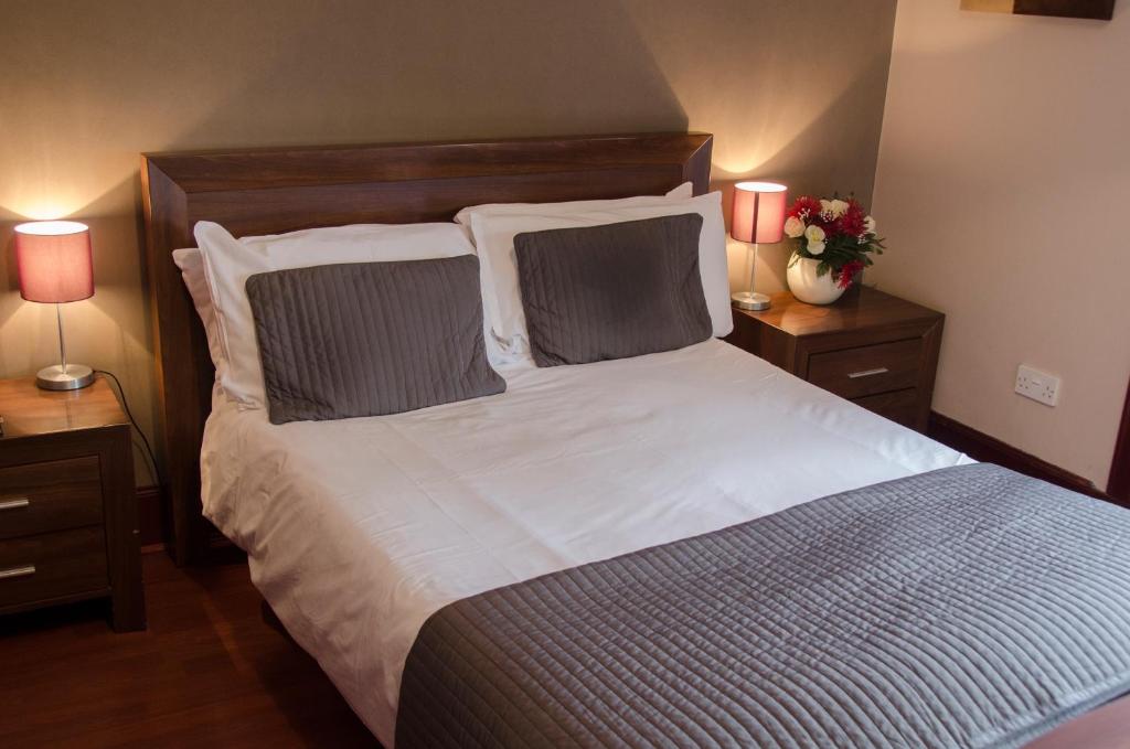 a bedroom with a large bed with two night stands at The Fullarton Park Hotel in Glasgow