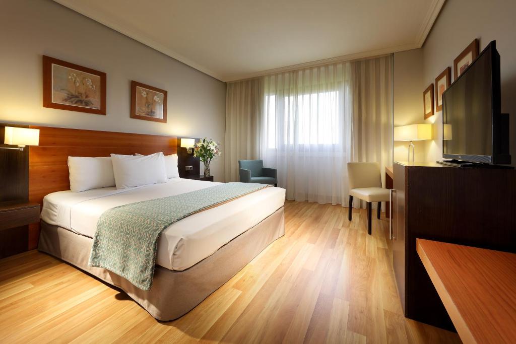 pokój hotelowy z łóżkiem i telewizorem z płaskim ekranem w obiekcie Exe Getafe w mieście Getafe