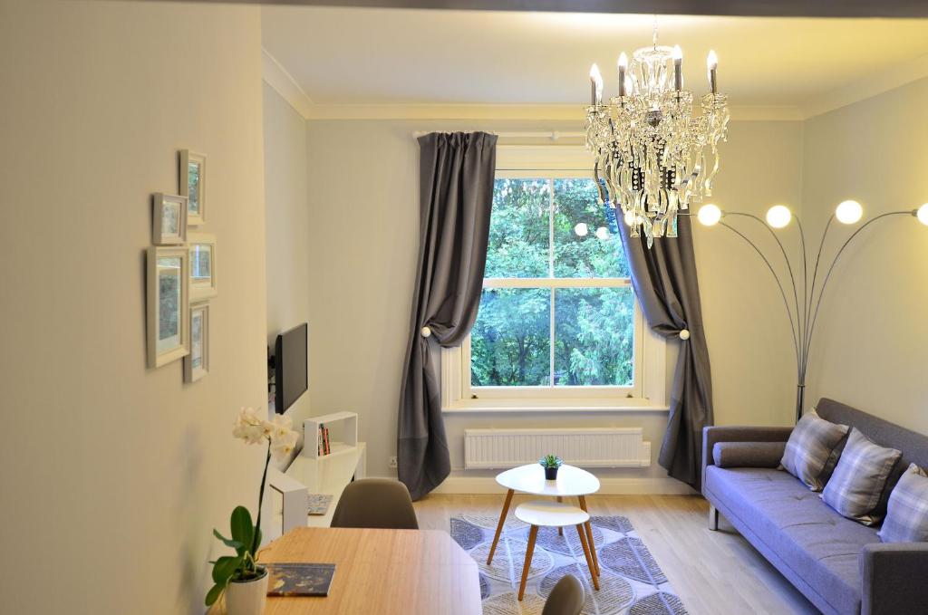 a living room with a blue couch and a window at London, Kensington and Chelsea Flat in London