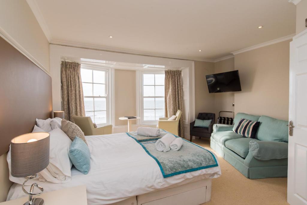 a bedroom with a large bed and a couch at No 46 Marine Terrace in Aberystwyth