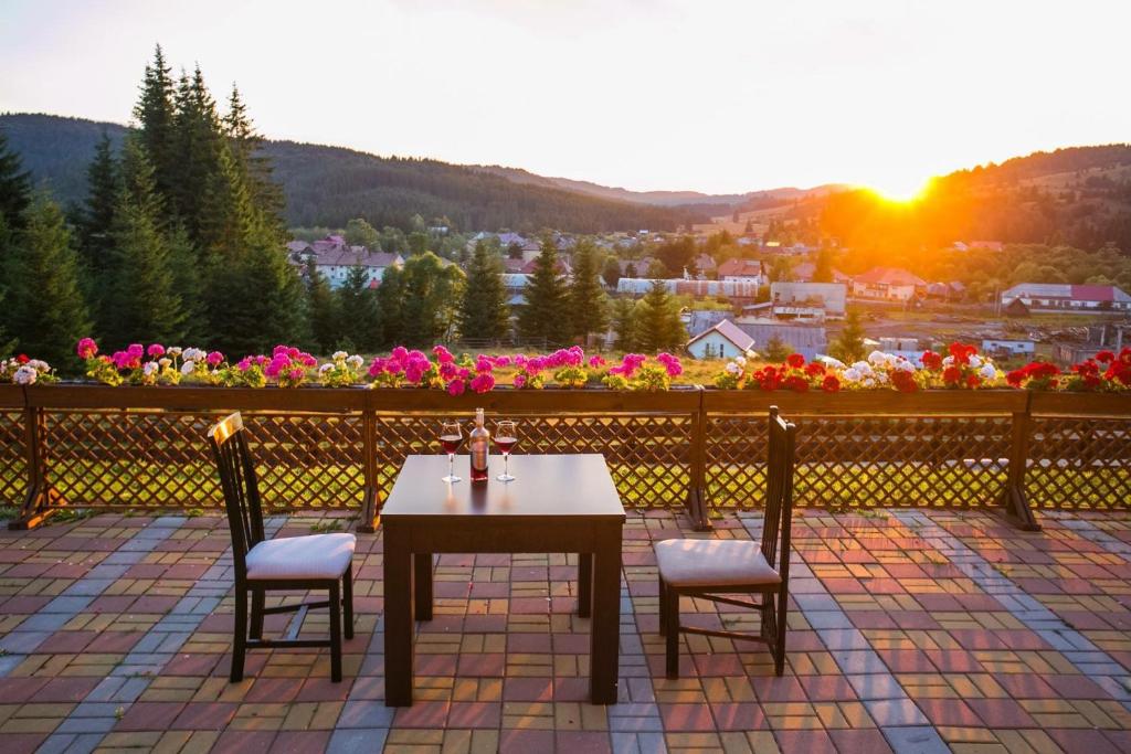 a table and two chairs on a patio with the sunset at Cabana Free Land in Comandău