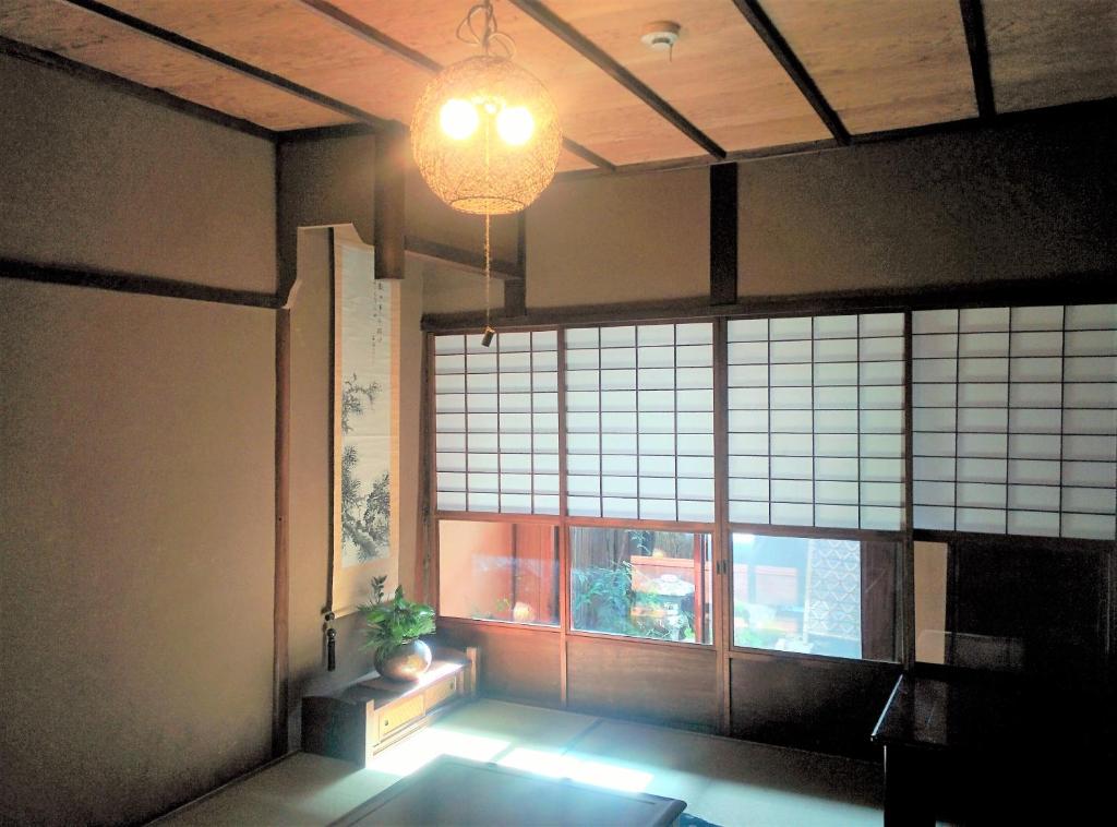 een kamer met een groot raam en een potplant bij Murasakino Guesthouse in Kyoto