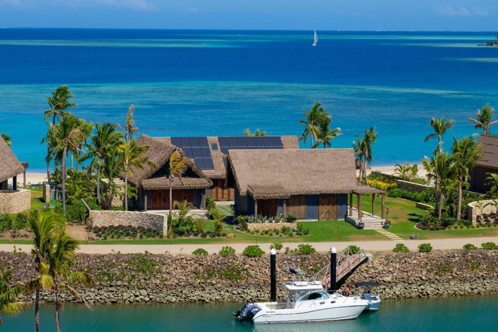 a boat in the water in front of a house at My Vunabaka in Malolo