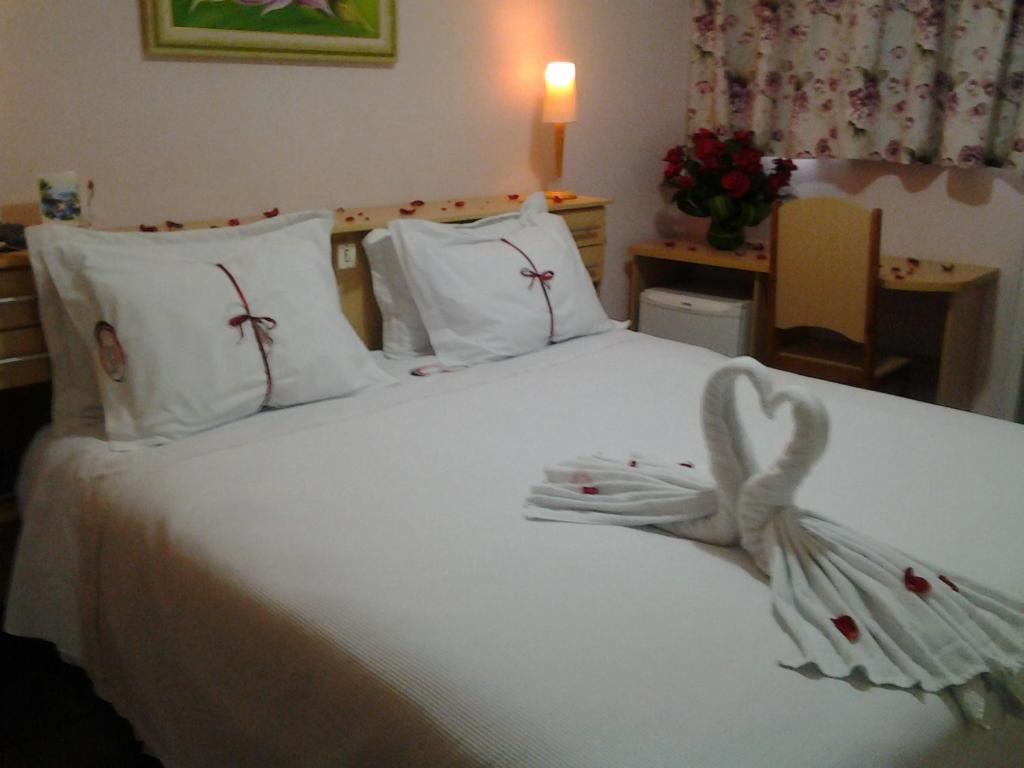 een slaapkamer met een wit bed met een boog erop bij Hotel Mirante in Barra Velha