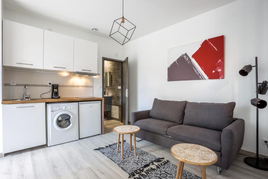 a living room with a couch and a kitchen at Oyonnappart in Oyonnax