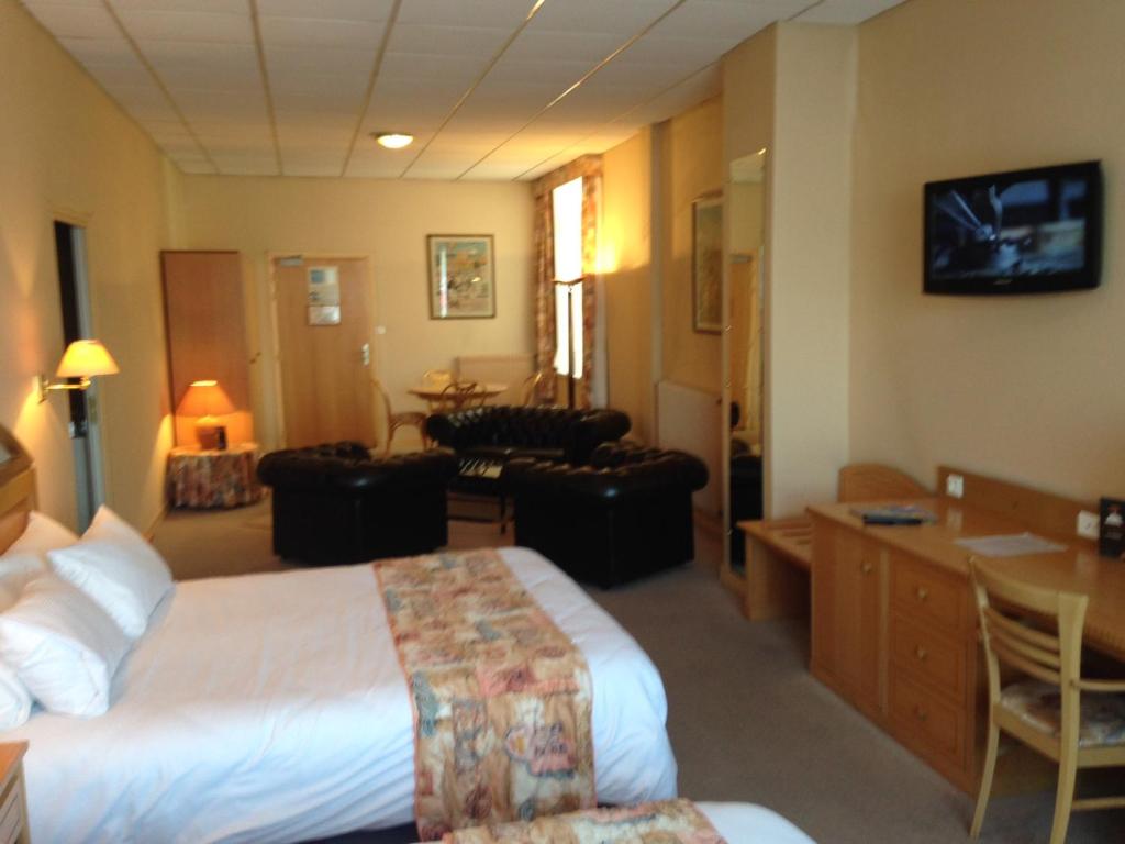 Habitación de hotel con cama y sala de estar. en Metropol Hotel, en Calais