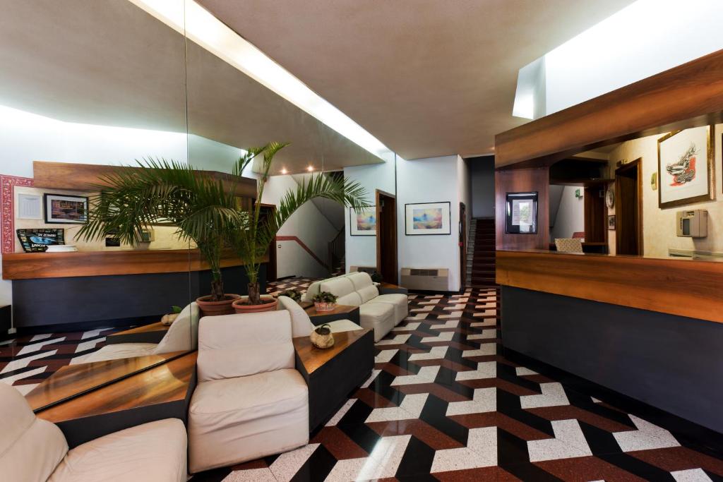 Hotel Letizia في أورتيه: غرفة معيشة بأثاث أبيض ونبات الفخار