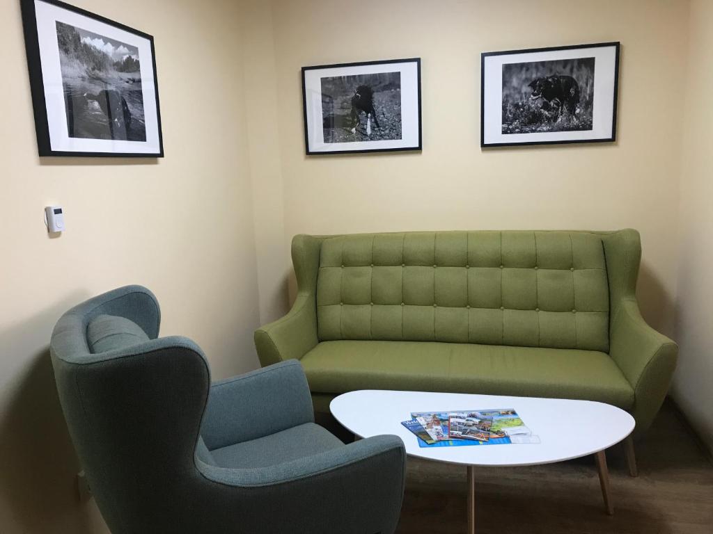 a living room with a green couch and two chairs at Apartman illy in Veľký Slavkov